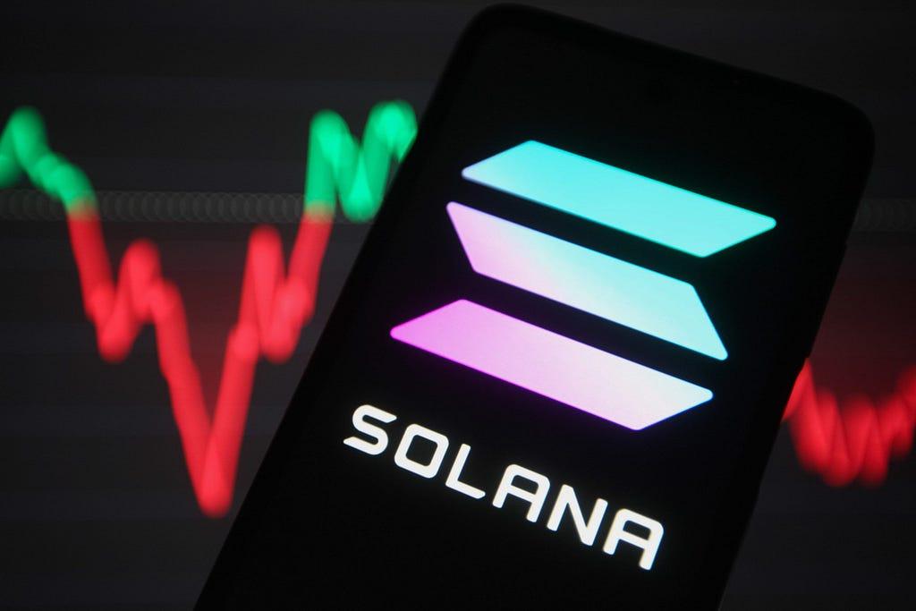 Solana logo on a phone in front of a price chart