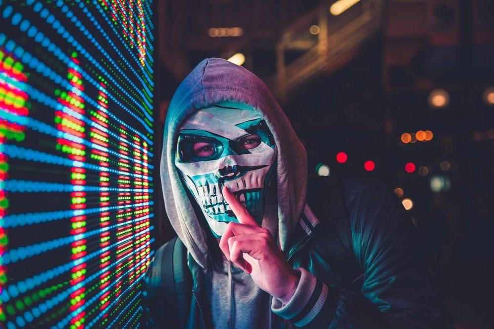 Person in a skull mask beside a wall of code, cover of Harry Ermawan's smart contract security notes